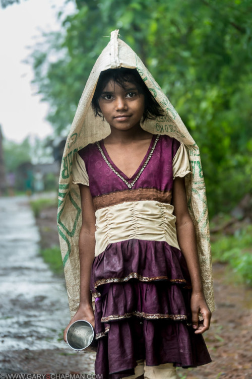 Young Indian girl in the rain on her way to get some water buffalo milk